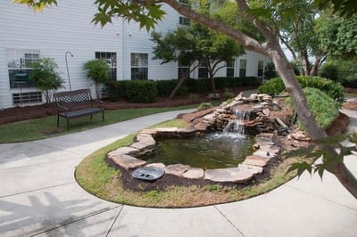 Serene outdoor space with a pond and seating area