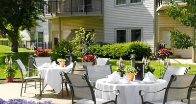 Outdoor dining setup with tables and chairs in a garden