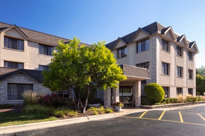 Exterior view of a senior living facility with greenery
