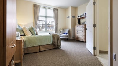 Cozy resident room with bed and comfortable chair