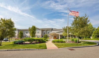 Front entrance of a senior living facility with gardens