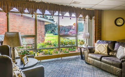 Interior lounge area with large windows and floral view