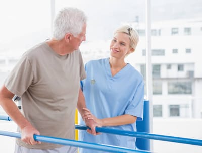 Therapist assisting senior man in a rehabilitation setting