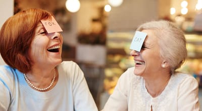 Two women laughing while playing a game.