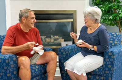 Two residents enjoying ice cream in a cozy common area