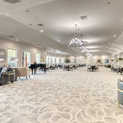 Common area with seating and chandeliers in a senior living facility