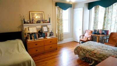 A cozy resident room with a bed and bookshelf