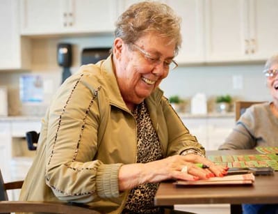 Resident enjoying a game of bingo with a smile