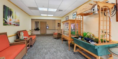 Complete Care At Holmdel Llc, nursing home in Holmdel, NJ — Bright corridor with seating and decorative displays