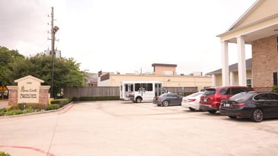Exterior view of the facility with parked cars and shuttle