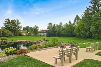 Patio area with benches overlooking a serene pond