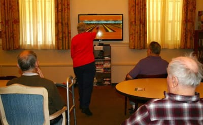 Residents enjoying virtual bowling activity in a common area