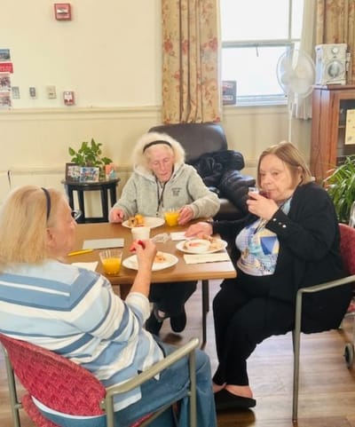Residents enjoying a meal together in the common area