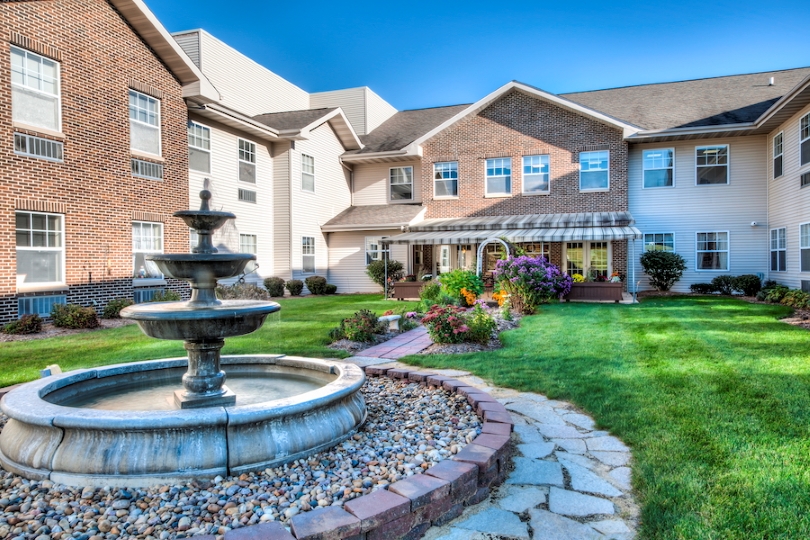 Beautiful garden area with a fountain and building in background