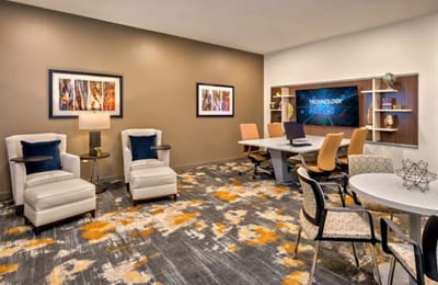 A modern common area with seating and technology.