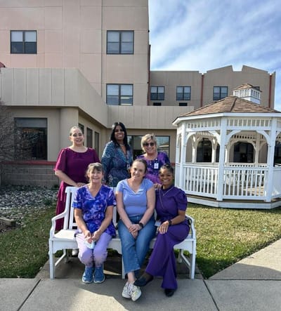 Staff posing outside facility near gazebo