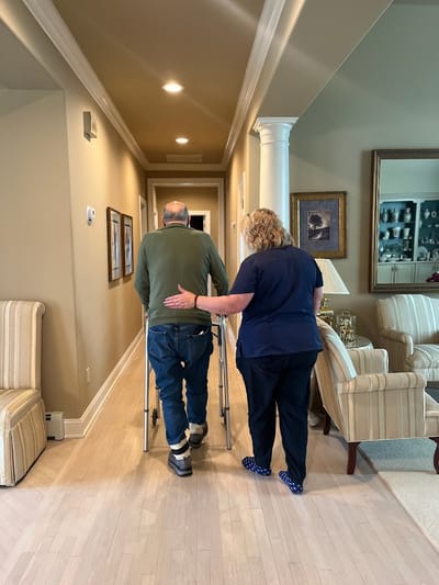 Staff assisting a resident in a hallway