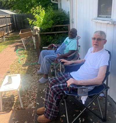 Two residents relaxing in outdoor chairs