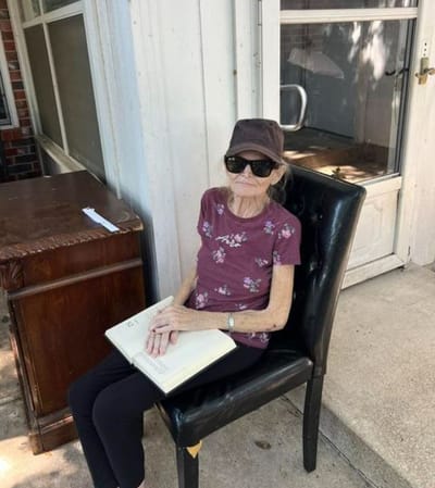 Resident reading outside on a sunny day