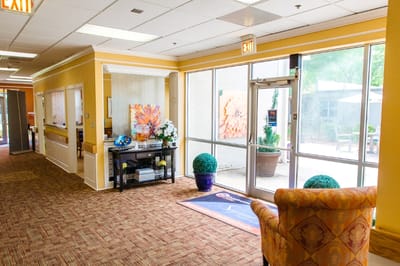 Bright interior lobby area with seating and view of garden
