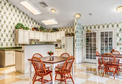 Bright dining area with wooden tables and floral wallpaper