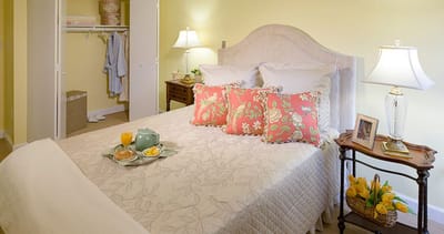 Cozy bedroom setup with breakfast tray and flowers