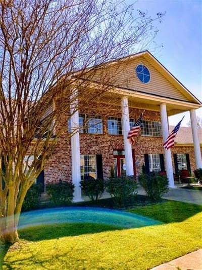 Exterior view of a senior living facility with flags