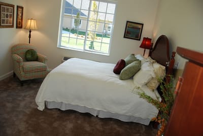 Cozy resident room with bed and armchair