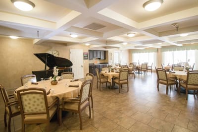 Dining room set up with tables and a piano