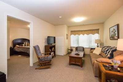 Cozy living room of a resident's unit with a bedroom visible