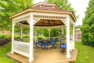 Outdoor gazebo with seating in a landscaped area