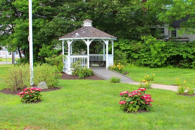 Gazebo in a lush green garden with flowers