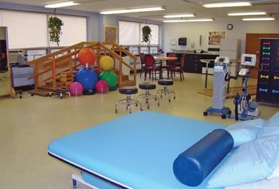 Rehabilitation therapy room with equipment and exercise balls.