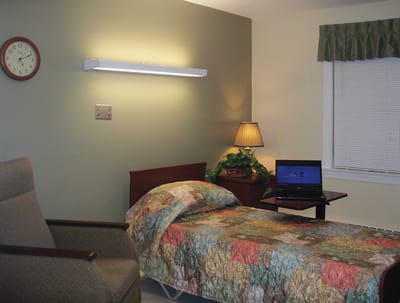Private resident room with a bed and lamp.