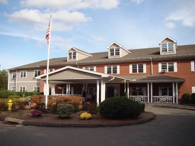 Exterior view of the facility with landscaping and flag.
