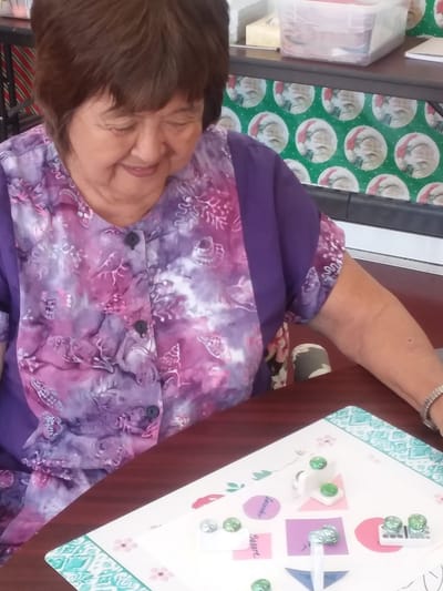Resident engaging in a craft activity at a table.