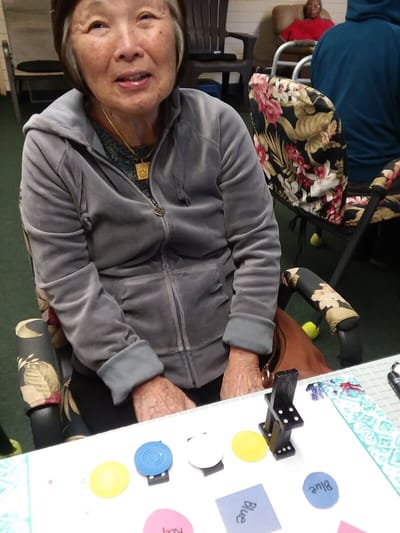 Resident engaging in an activity with colored discs.