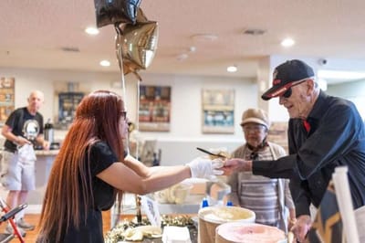 A staff member serving ice cream to a resident