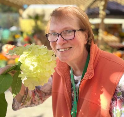 A resident enjoying a flower in an outdoor space