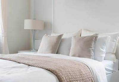 A well-decorated bedroom with neutral tones and soft bedding