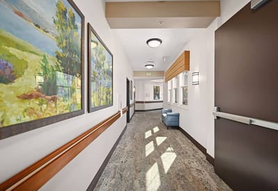 Brightly lit hallway with artwork and seating area