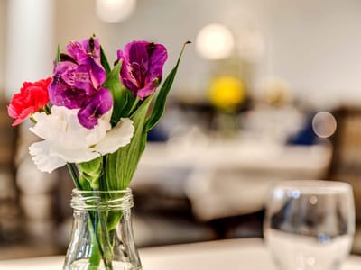 A vase of colorful flowers on a dining table