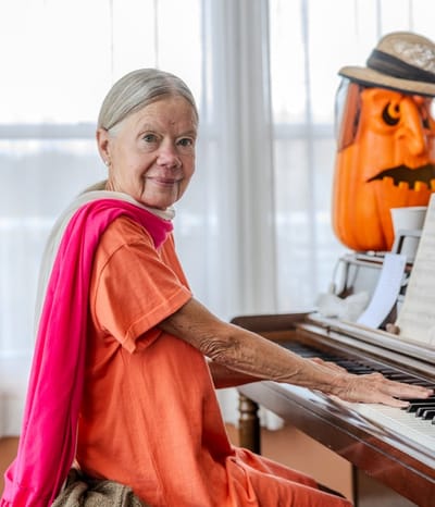 Elderly woman playing piano in a common area