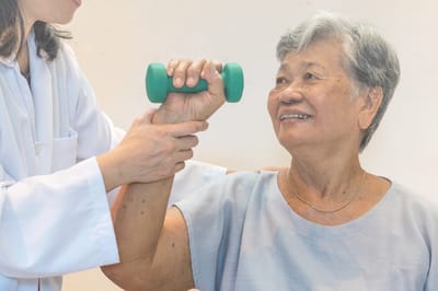 Therapist assisting senior woman with exercise