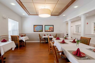 Dining room set up for a meal with tables and decorations