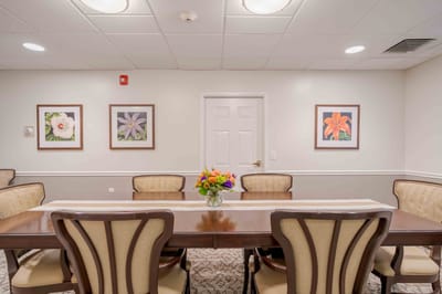 Brightly lit dining area with floral decor and artwork