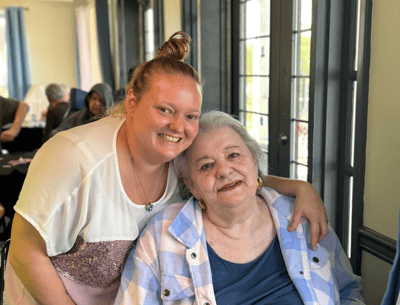 Staff member posing with a resident in a common area