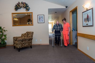 Care staff assisting a resident in the hallway