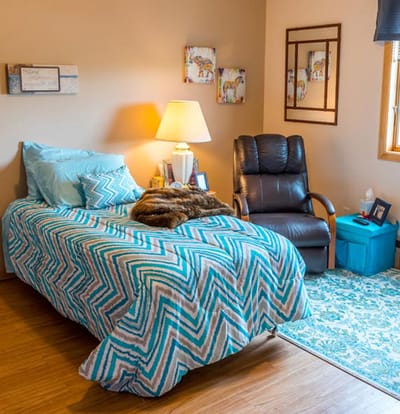 Cozy private resident room with bed and armchair