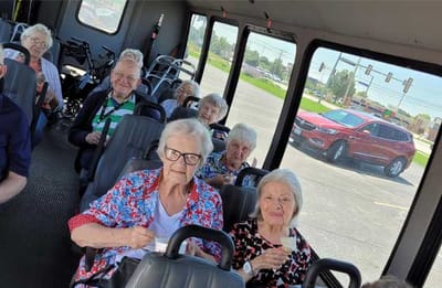 Residents enjoying ice cream on a facility shuttle bus